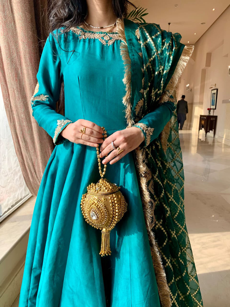 THE EMERALD STORY | RJ'S PRET teal pishwas with golden embroidery and zardozi work, model holding embellished bag